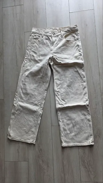Cream straight leg jeans, laid flat